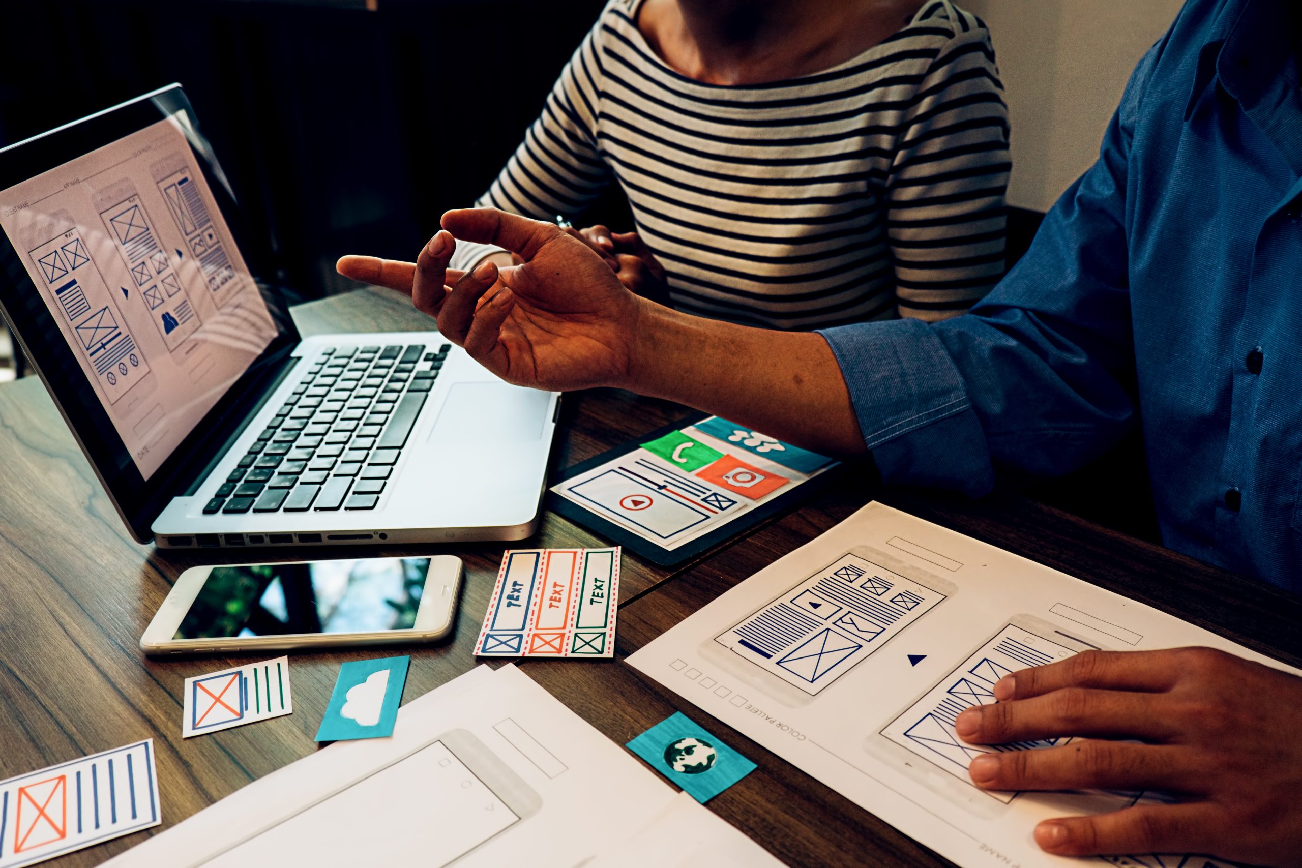 Two people actively brainstorming and planning on a desk showing the early creative process of developing an Instagram account from scratch. 